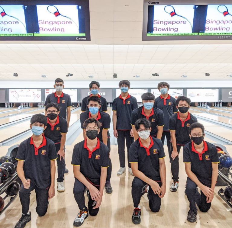 The ACS(I) bowling team poses in formation on the lanes at a bowling alley.